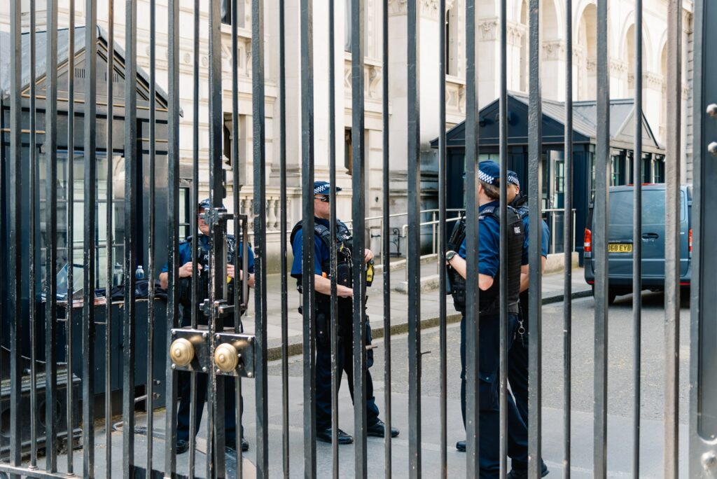 Police officer guarding 10 Downing Street entrance gate in the City of Westminster