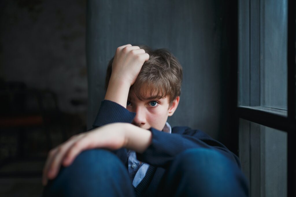 Pensive sad teenager boy.