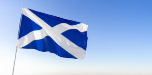 Flag of Scotland waving against blue sky