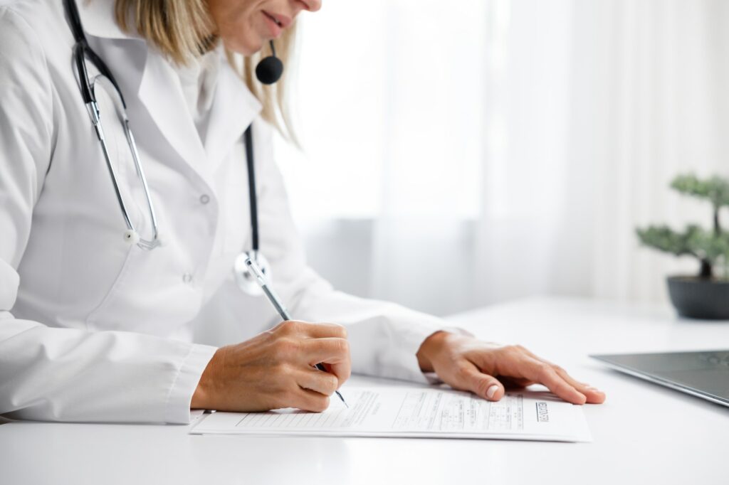 Woman medic, doctor writes out a prescription. Makes an entry in the medical record. Medical